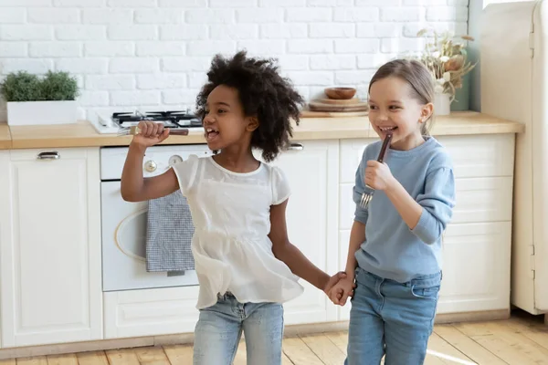 Kleine gemischte Vorschulkinder genießen das Liedsingen in der Küche. — Stockfoto