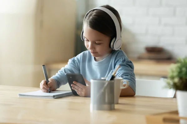 Gericht klein Europees kind met behulp van smartphone voor studie. — Stockfoto