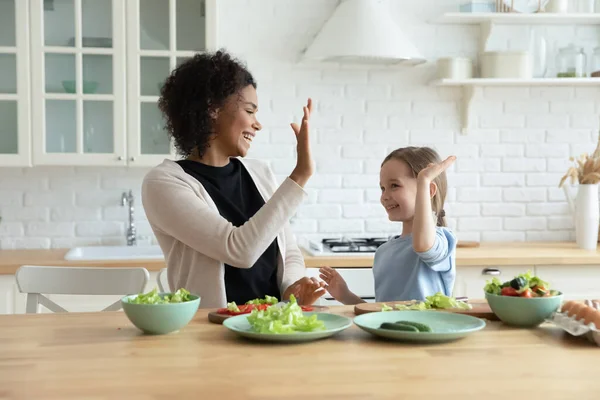 Glückliche afrikanische Mutter gibt Adoptivtochter High Five. — Stockfoto