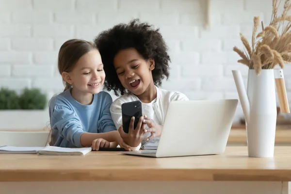 Verslaafd aan technologie kleine gemengde ras kinderen met behulp van mobiele telefoon. — Stockfoto