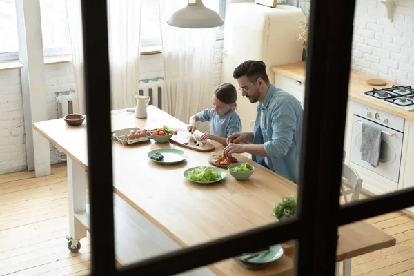 Liebender Vater kocht in Küche mit kleiner Tochter. — Stockfoto