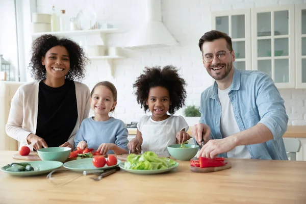 Porträtt av glada multiracial familj matlagning i kök med barn. — Stockfoto