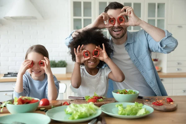 Gülen çok ırklı aile, mutfakta komik suratlar yapıyor..