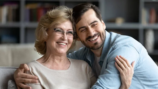 Überglückliche reife Frau und erwachsener Sohn umarmen sich, posieren für Foto — Stockfoto