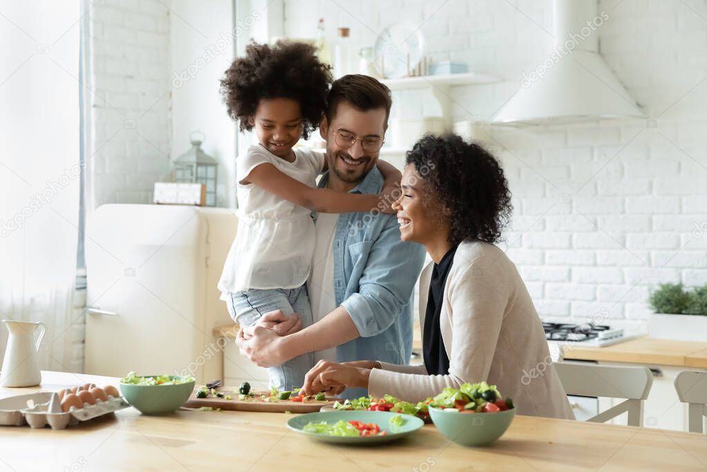 Happy multiracial family involved in cooking process.