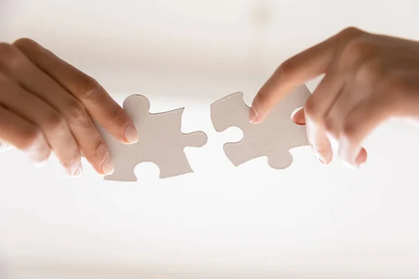 Close up of two people assemble jigsaw puzzle — Stock Photo, Image