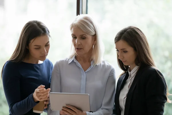 Focused female colleagues cooperate at tablet together — Stock Photo, Image
