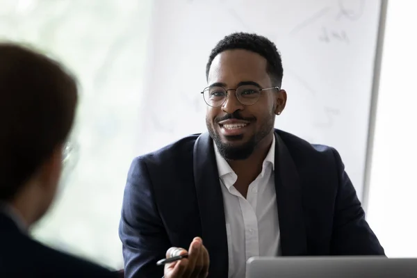 Sonriente birracial hombre de negocios hablar con su colega en la reunión —  Fotos de Stock