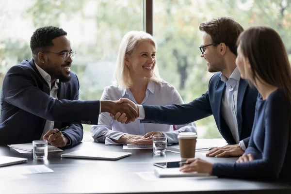 Smiling diverse employees handshake at briefing in office — Stock Photo, Image