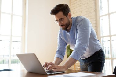 Ciddi Kafkasyalı patron dizüstü bilgisayarda yazmakla meşgul.