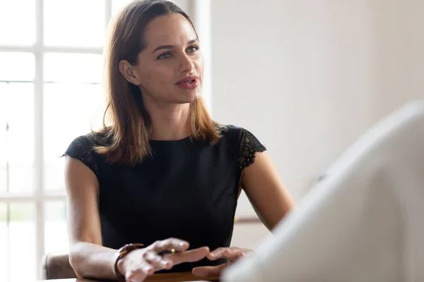 Confident Caucasian woman talk negotiating at meeting in office