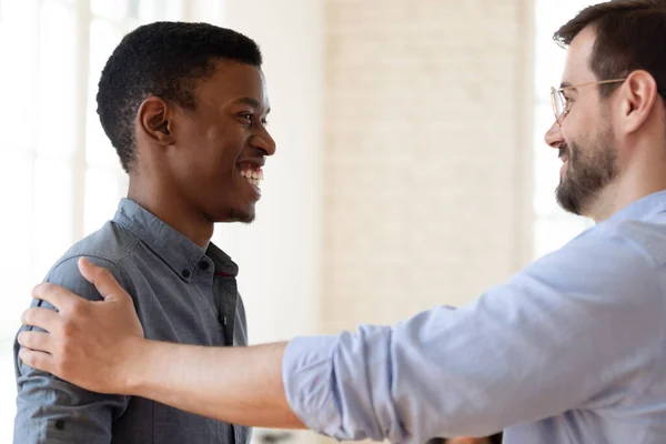 Smiling diverse colleagues talk cooperating in office — Stock Photo, Image