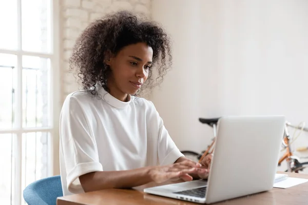 Afro-Amerikaanse vrouwelijke werknemer druk bezig met laptop — Stockfoto