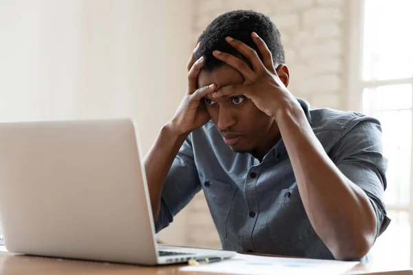 Angry biracial male employee annoyed with laptop operational problems — Stock Photo, Image