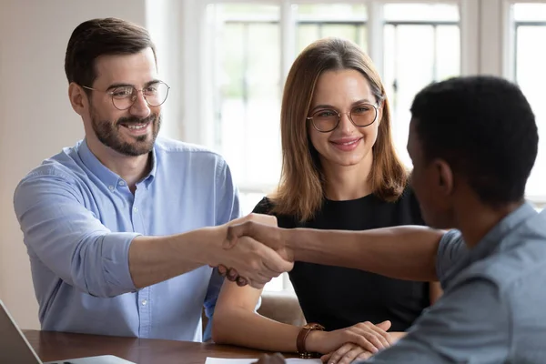 African American realtor handshake happy couple closing deal in office — Stock Photo, Image