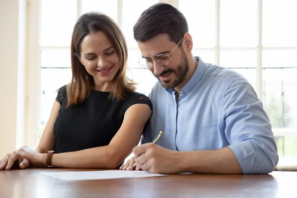 Happy Caucasian couple sign deal buying house together — Stock Photo, Image