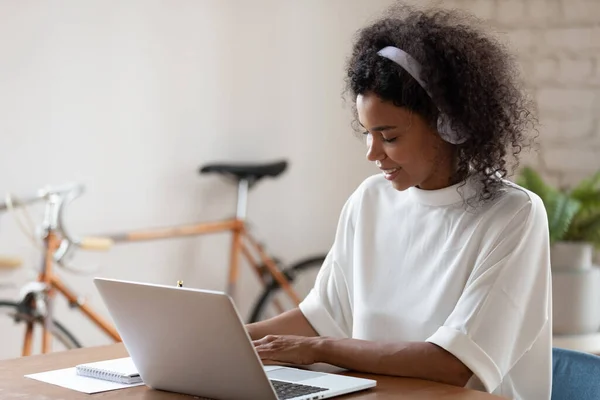 Africká americká mladá žena ve sluchátkách sledovat online školení — Stock fotografie