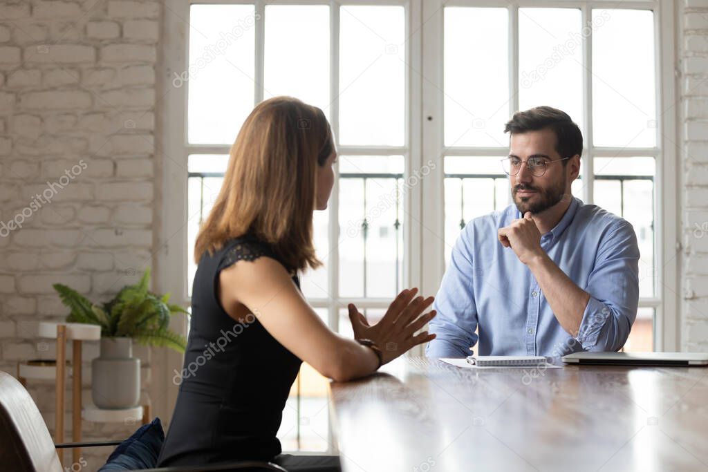 Focused business partners negotiate at meeting in office