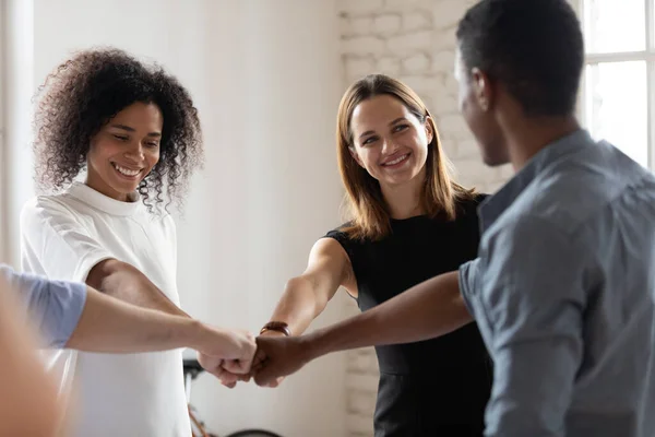 Diversos empresarios alegres se unen a los puños comprometidos en la creación de equipos — Foto de Stock