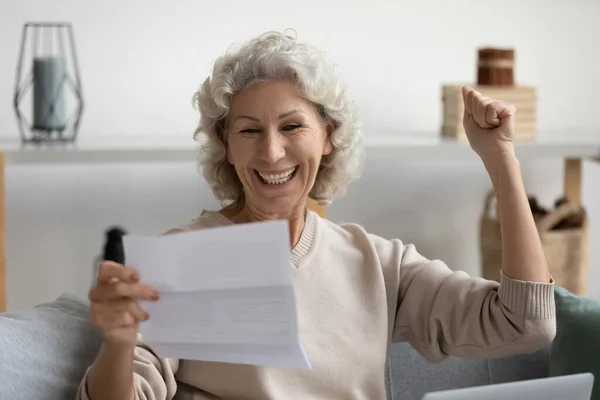 Χαρούμενη χαμογελαστή μεσήλικη γυναίκα που διαβάζει καλά νέα με γράμμα. — Φωτογραφία Αρχείου