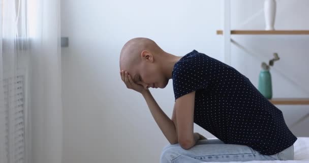 Skallig kvinna som sitter på sängen känner sig hopplös på grund av cancer sjukdom — Stockvideo