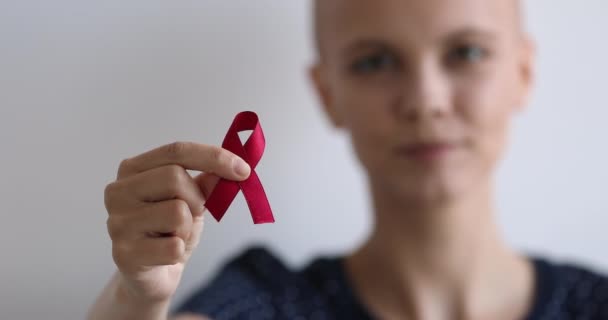 Mujer calva mostrando a la cámara roja cinta de conciencia simbólica — Vídeo de stock