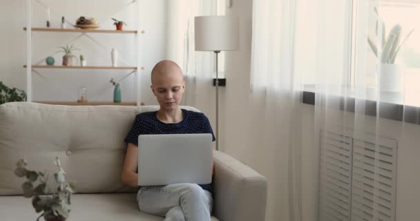 Mujer calva sentarse en el interior utilizar el ordenador portátil pasar tiempo en Internet — Vídeos de Stock