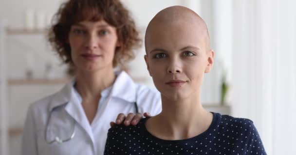 Középkorú nővér áll a rákos beteg arcképe mögött. — Stock videók