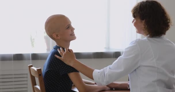 Врач-онколог во время беседы касается плеча лысого больного раком — стоковое видео