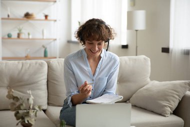 Gülümseyen beyaz kadın laptopta çalışıyor.