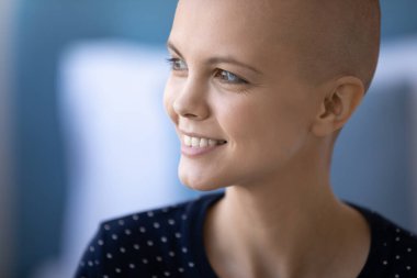 Kanserli, kılsız, gülümseyen kadın iyileşme hayali kuruyor.