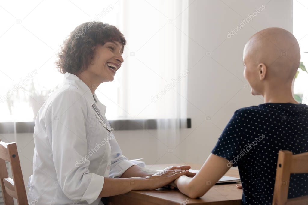 Smiling doctor support sick female cancer patient at meeting
