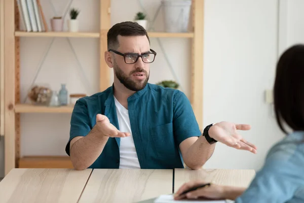 Missnöjd klient ung man bär glasögon gräla med chefen — Stockfoto