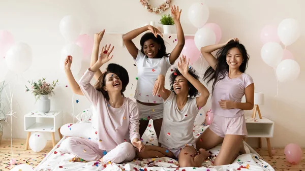 Energetic jóvenes diversas chicas multiétnicas jugando con confeti colorido. —  Fotos de Stock