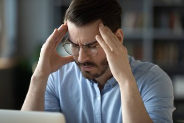 Hasta genç adam iş yerinde baş ağrısı çekiyor.