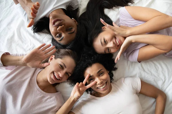 Bonito brincalhão mestiço mulheres se divertindo na festa de pijama. — Fotografia de Stock