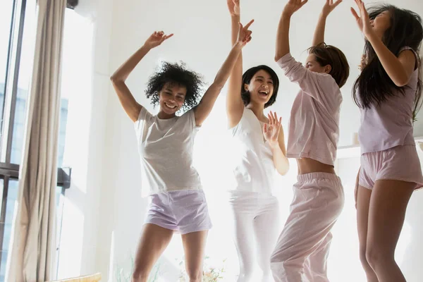 Young mixed race girl dancing on bed. — Stock Photo, Image