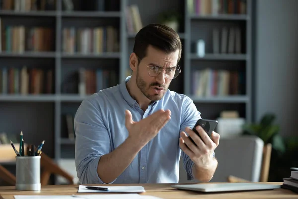 Homem louco olhar para a tela celular estressado com problema gadget — Fotografia de Stock