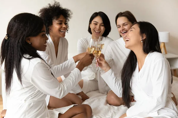 Heyecanlı genç kızlar kadehlerini şampanyayla tokuşturuyorlar..