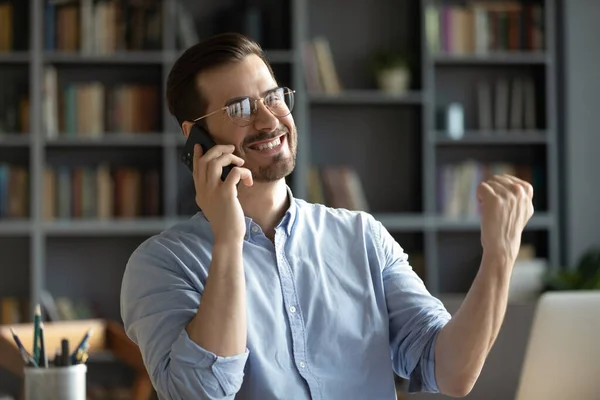 Excited man feel euphoric having good news on cellphone