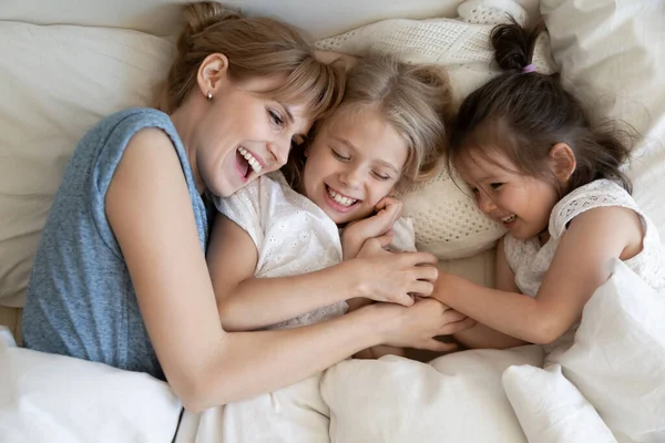 Mama en kinderen knuffelen in bed — Stockfoto