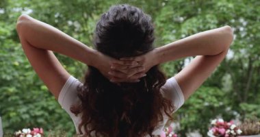 Arka manzara, yaz terasında uyanmış bir kadın taze hava soluyor.