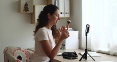 Makyaj sanatçısı, elinde toz fırçası tutan video günlüğünü kaydederek profesyonel tavsiyelerde bulunuyor