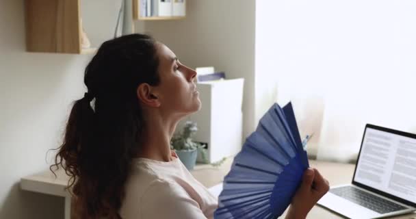 Стрессовая женщина машет вентилятором охлаждения себя чувствует перегревается дома — стоковое видео