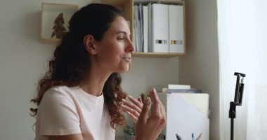 Masada oturan kadın, telefonu tripod kayıt videosuna kaydetti.