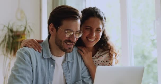 Ευτυχισμένο ζευγάρι που αγοράζει στο διαδίκτυο χρησιμοποιώντας φορητό υπολογιστή στο σπίτι — Αρχείο Βίντεο