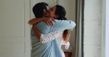 Sevgili çift uzun bir ayrılıktan sonra kucaklaşıyorlar. Evde duruyorlar.