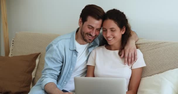 Couple se détendre sur le canapé avec ordinateur portable discuter intrigue regarder film — Video