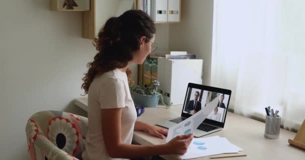 Affärskvinna diskutera finansiella dokument med kollegor med hjälp av videokonferens och bärbar dator — Stockvideo