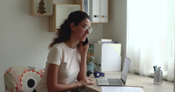 Бізнес-леді пише нотатки під час розмови по телефону з колегою — стокове відео